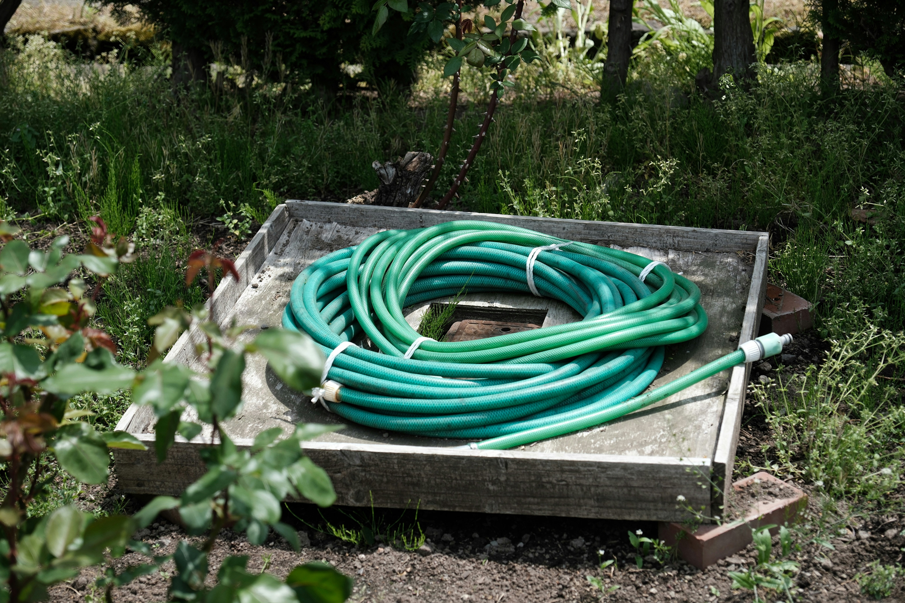 Gartenschlauch beim Abspülen von Terrassenfliesen